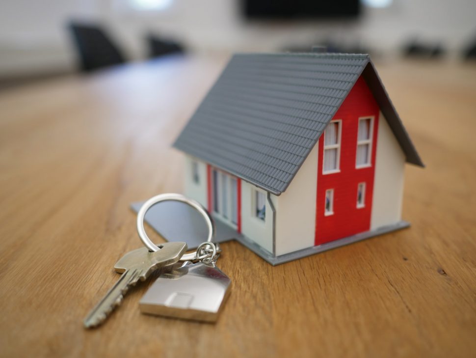 A key and small model of a house on the table