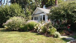 Flowers and plants in front of a house.