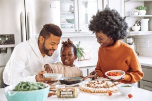 Two adults and a child playing with food