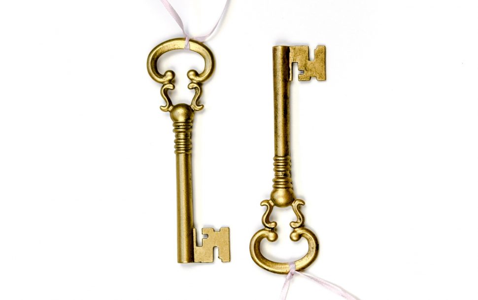 Two gold keys, representing how to sell and buy a house at the same time