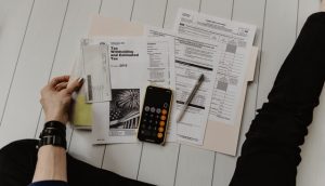 A person sitting on the floor and calculating their budget