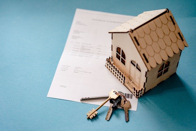 A keychain and a toy house on a contract, symbolizing selling your Arizona house and buying in another state.