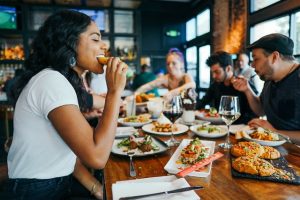 A woman eating with friends in a restaurant