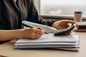 A person using a calculator to work out costs related to buying a house after retirement