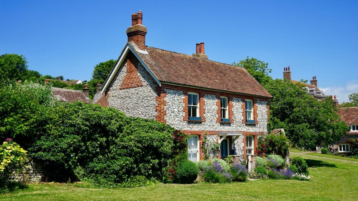 A house with a brown roof and windows surrounded by greenery