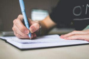 Person writing something in a notebook 